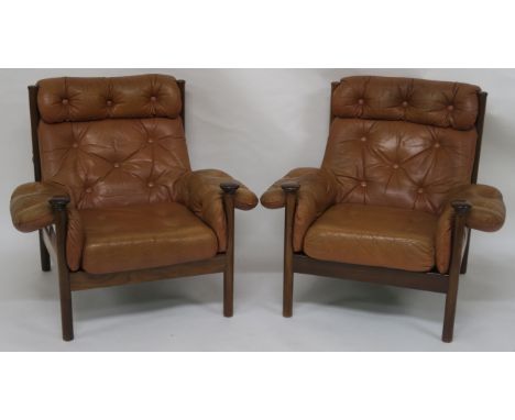 A PAIR OF MID 20TH CENTURY GUY ROGERS FOR HEALS SANTA FE BUTTON BACK TAN LEATHER ARMCHAIRS with shaped teak frames 89cm high 