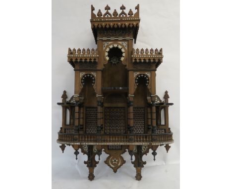 A MOORISH STYLE MOTHER OF PEARL INLAID WALL DISPLAY CABINET with pierced castellated shelves, set with script medallions and 