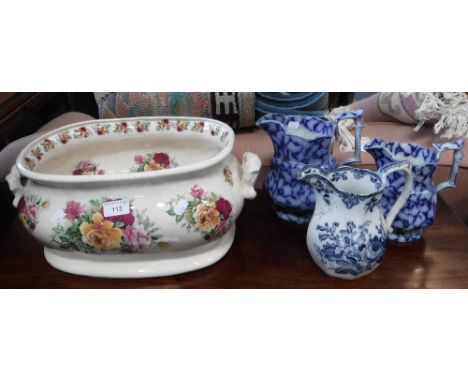 A VICTORIAN STYLE CERAMIC FOOT BATH, decorated with roses and three 19th century blue and white jugs