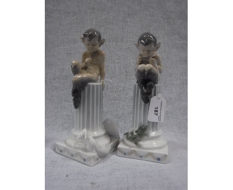 A PAIR OF DANISH ROYAL COPENHAGEN FIGURES OF PAN PLAYING THE PIPES on top of a short column