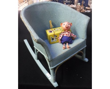 A VINTAGE LLOYD LOOM CHILD'S ROCKING CHAIR, in blue with musical action and a Pelham 'Pinky' puppet (2)