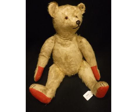 STEIFF: AN EARLY 20TH CENTURY BEAR with jointed limbs and head, with 'hump' back, button still intact with repaired red paws,