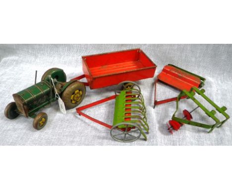 A VINTAGE TIN-PLATE GREEN TRACTOR (stamped made in Gt. Britain) with trailer and farming implements