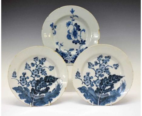Three mid 18th Century English Delftware plates, possibly Liverpool, two painted with prunus, the third with trailing peony a
