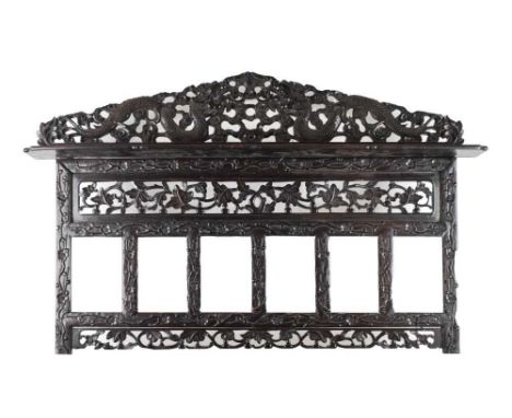 Chinese carved hardwood overmantel, circa 1900, with dragon-carved pediment over shelf and six rectangular apertures bordered