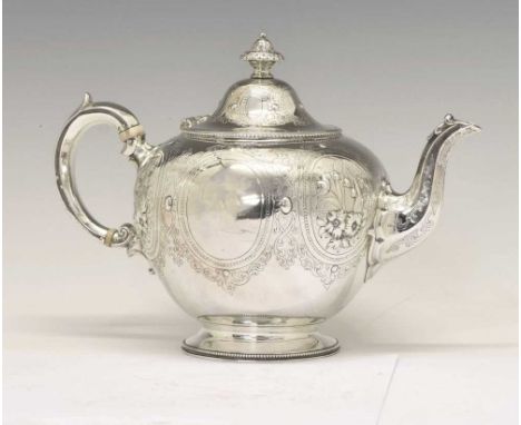 Victorian silver teapot of circular form with engraved decoration and embossed foliate panels, standing on a circular pedesta