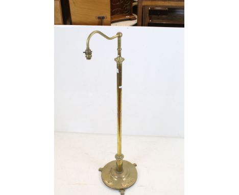 Late 19th / Early 20th century Brass Standard Reading Lamp, the circular base with three scroll feet 