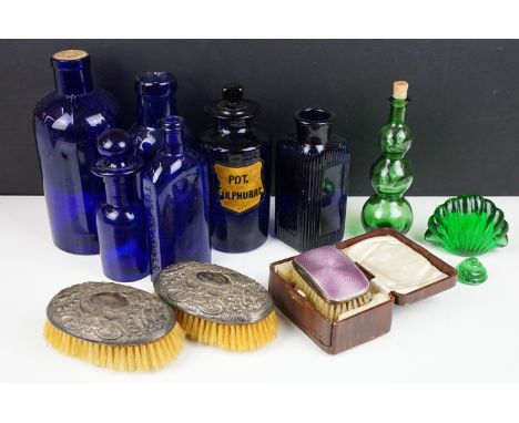 A small group of collectables to include glass medicine bottles, two hallmarked silver clothes brushes together with two guil