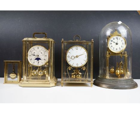 Group of four 20th Century anniversary clocks to include a glass domed example, a Sewills moon phase example, brass and glass