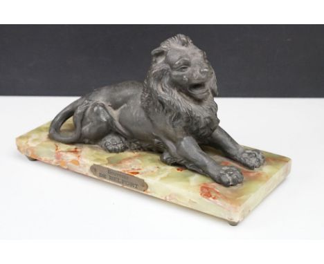 'Souvenir de Belfort' spelter figure of a recumbent lion, raised on a rectangular onyx base, 22cm wide; plus a M. Hohner 'The