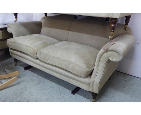 'RECLINE AND SPRAWL' SOFA, Georgian style with arched back, scroll arms, feather filled cushions and turned supports with cas