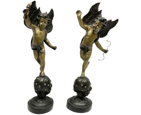 Pair of late 19th century French bronze figures, modelled as two putti stood upon celestial globes, one example holding a fla