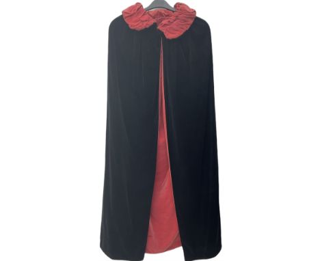Full length 1930's childs black velvet cape, with ruched collar and red velvet lining, with a single button neck fastening 