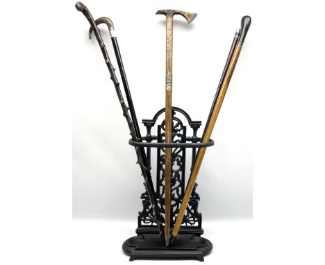 Cast iron walking stick stand, in the manner of Coalbrook, together with five walking sticks, to include horn handled example