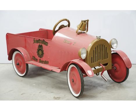 Large red metal pedal car in the form of a vintage Fire Truck, 'Australian Fire Service' decal to sides, some discolouring bu