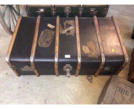 A wooden bound steamer trunk with old luggage labels attached