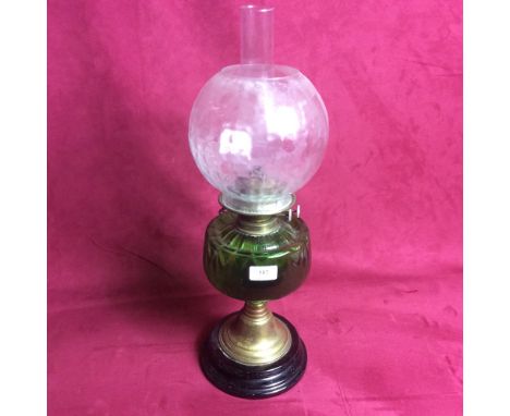 A Victorian oil lamp with green glass font