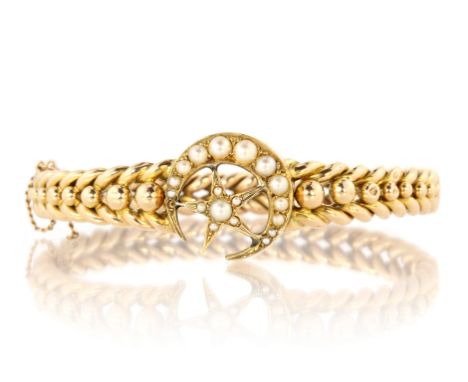 An antique Victorian pearl crescent and star bangle in high carat yellow gold designed as a pearl set star within a similarly