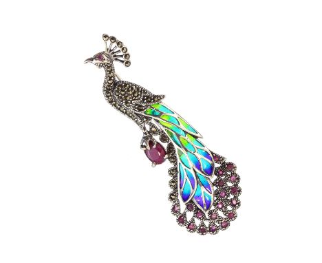 A ruby, marcasite and plique a jour enamel brooch in Sterling silver designed as a peacock stood atop a ruby, with further ru