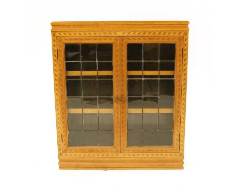 An early 20th Century inlaid oak and parquetry glazed bookcase, the stepped rectangular top with parquetry inlay within a che