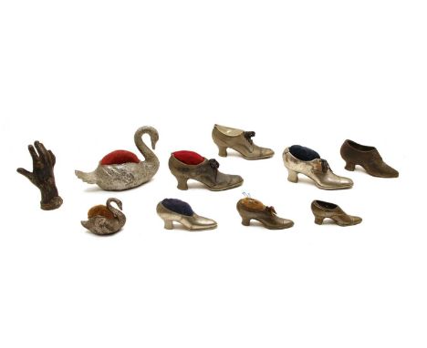 Miscelleaneous items, comprising: four metal shoe and two swan pin cushions, a shoe money box, two further shoes and metal ha