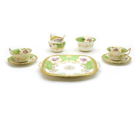 A Victorian porcelain tea set, green and gilt with printed flowers, comprising twelve cups and saucers, 12 plates, a milk jug