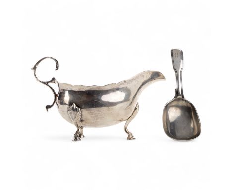 with s-scroll handle and on three feet, along with a silver caddy spoon 116g gross the sauce boat 13cm wide