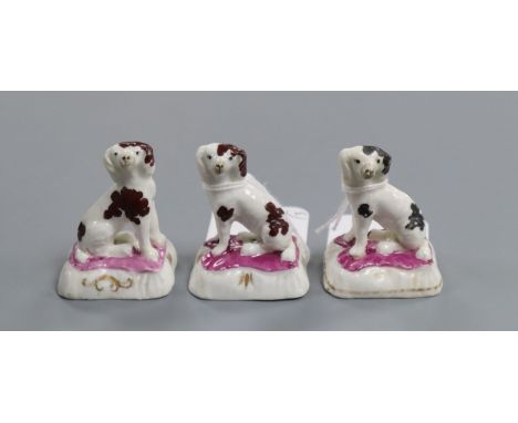 Three Staffordshire porcelain figures of King Charles spaniels, with puce enamel to the bases, H. 5.2cmProvenance - Dennis G.