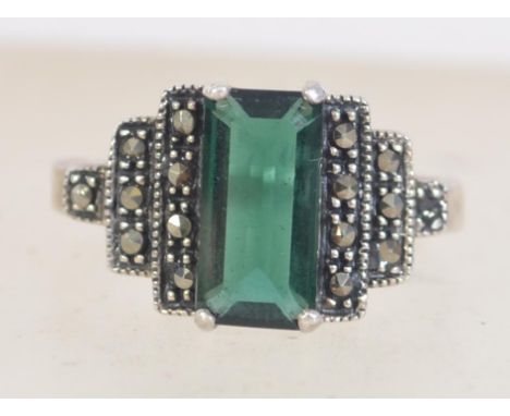 A silver 925 Art Deco style ladies dress ring with central baguette green stone with marcasite step shoulders. Ring size S we