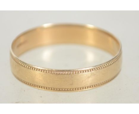 A hallmarked 9ct gold band ring with granulated decoration. Size R. Hallmarked for Birmingham.