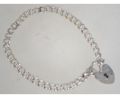 A vintage silver chain bracelet with heart lock. Marked Silver. Measures 8 inches.