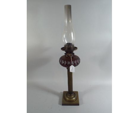 A Victorian Brass Column Oil Lamp with Coloured Glass Reservoir by Everedge.
