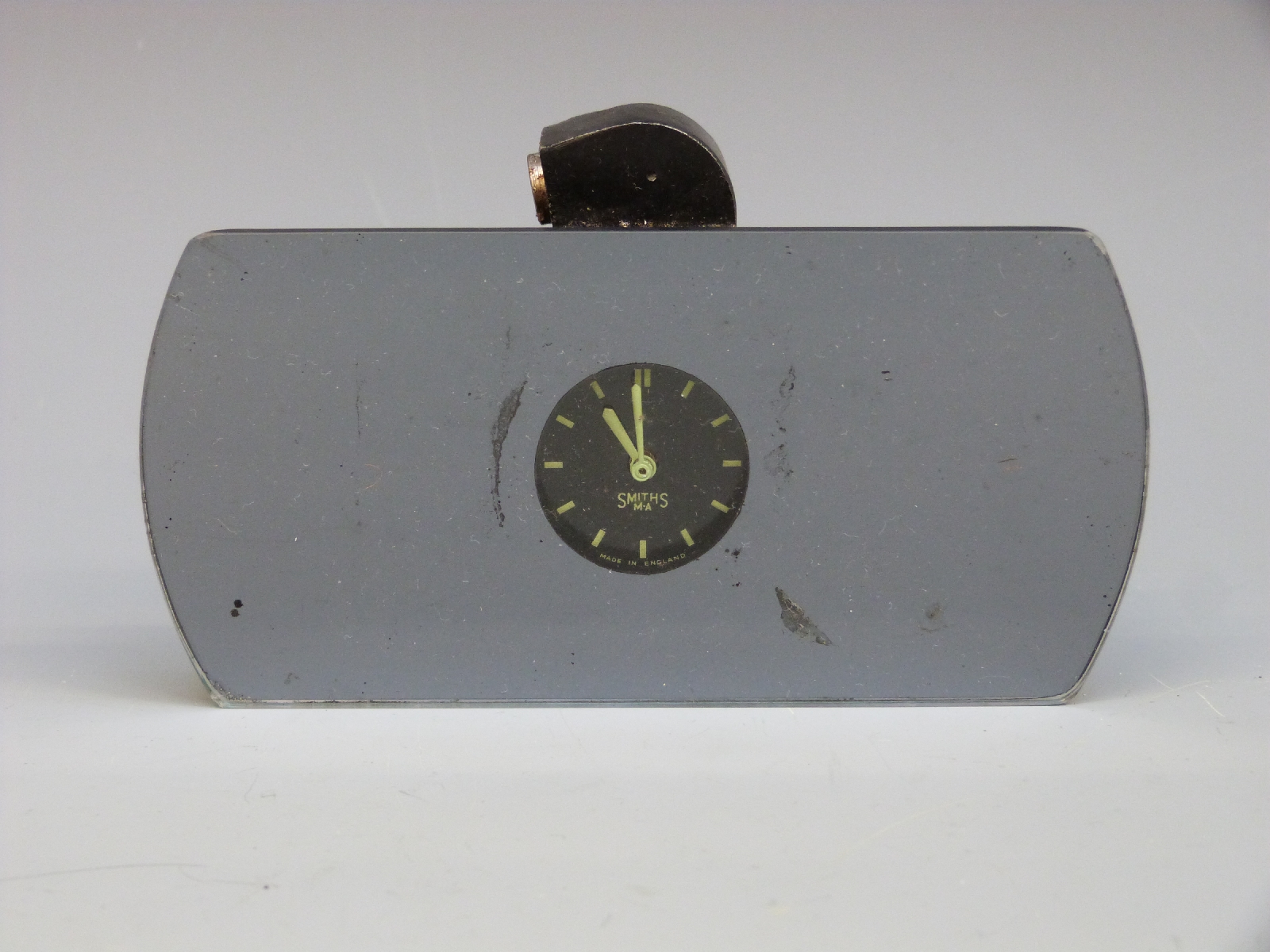 A classic or vintage car rear view mirror with inbuilt clock