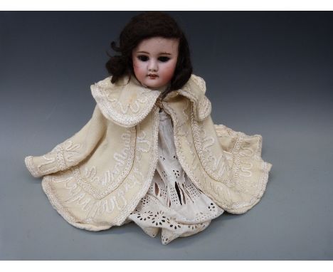 A French SFBJ bisque headed girl doll with open mouth, weighted brown eyes and jointed composition body in period cream wool 