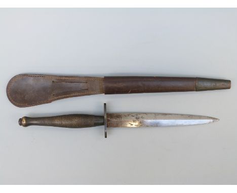 A WWII Fairbairn Sykes second pattern fighting knife, Wilkinson Sword, London with original metal tipped leather scabbard, bl