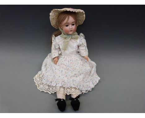 A Heinrich Handwerck bisque headed girl doll with open mouth, weighted brown eyes and jointed composition body in cotton flor