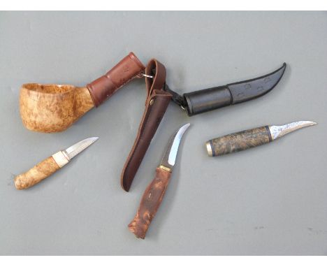 Three Finnish hunting knives each with wooden handles and leather sheaths, one in the form of a water ladle. 