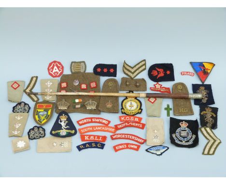 A collection of cloth insignia, rank and regimental badges including enamelled Gloucestershire Regiment, trench art, enamelle