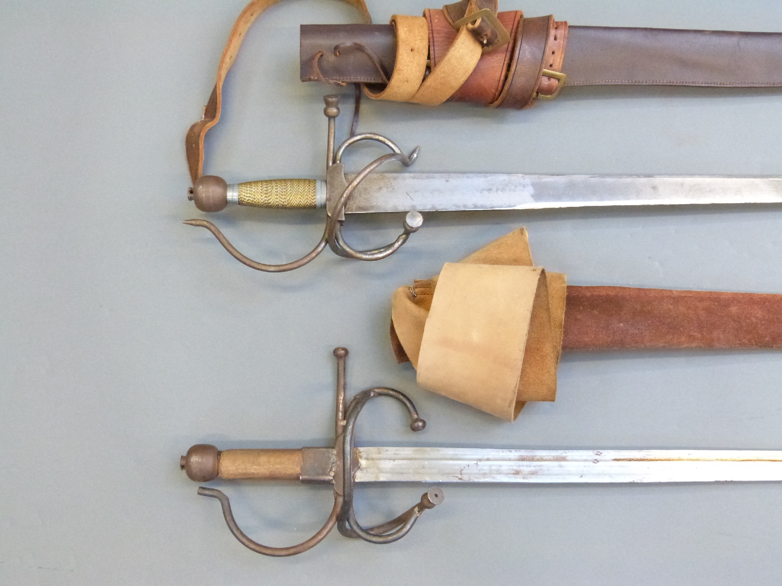 A pair of replica English Civil War swords with leather scabbards and ...