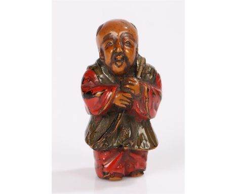 Japanese Meiji period netsuke, the painted wooden figure appearing to hold a rope with a stick at the end. 4.5cm