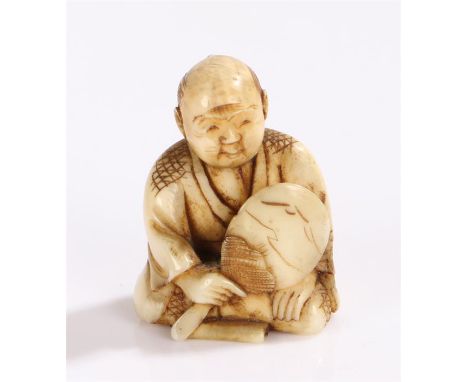 Japanese Meiji period ivory netsuke, carved as a seated man with a mirror, signed to the base, 4cm high