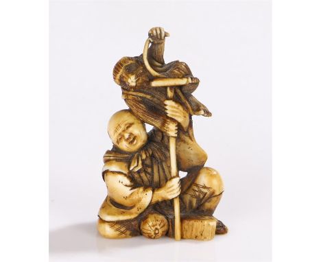 Japanese Meiji period netsuke, carved as a figure holding a staff with a monkey above, 4.5cm high
