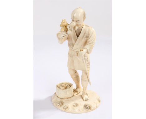 Japanese Meiji period ivory Okimono, carved as a fruit seller holding a stick, signed to the base Rakkuzan, 20cm high