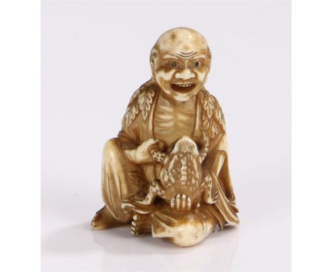 Japanese Edo period ivory gama sennin seated with a toad in his hand, his draping cloak carved with leaves. 5.5cm high