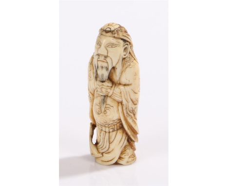 Japanese Meiji period ivory netsuke, carved as a samurai holding a weapon to his left arm, 6.5cm high