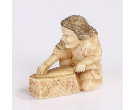 Japanese Meiji ivory netsuke depicting a squatting man sharpening a knife on a stone 4cm high