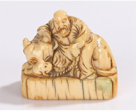 Japanese Edo period ivory netsuke, 18th Century, of a portly figure resting on a cow, 4cm wide