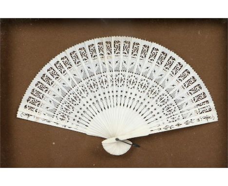 Victorian ivory fan, each stick carved with fret design and joined by silk, the fan glazed and framed