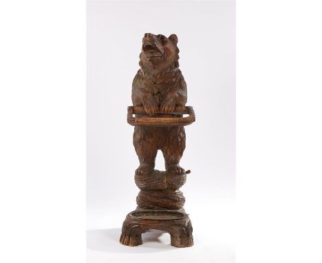 19th Century Black Forest carved bear stick stand, depicting a finely carved standing bear with glass eyes holding a looped s