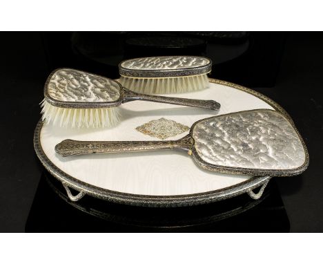 A Vintage Vanity Set White metal vanity set with cream silk moire detail comprises four items to include, hand mirror, tray a